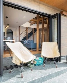 屋外テラスに置かれた椅子とリビングの様子